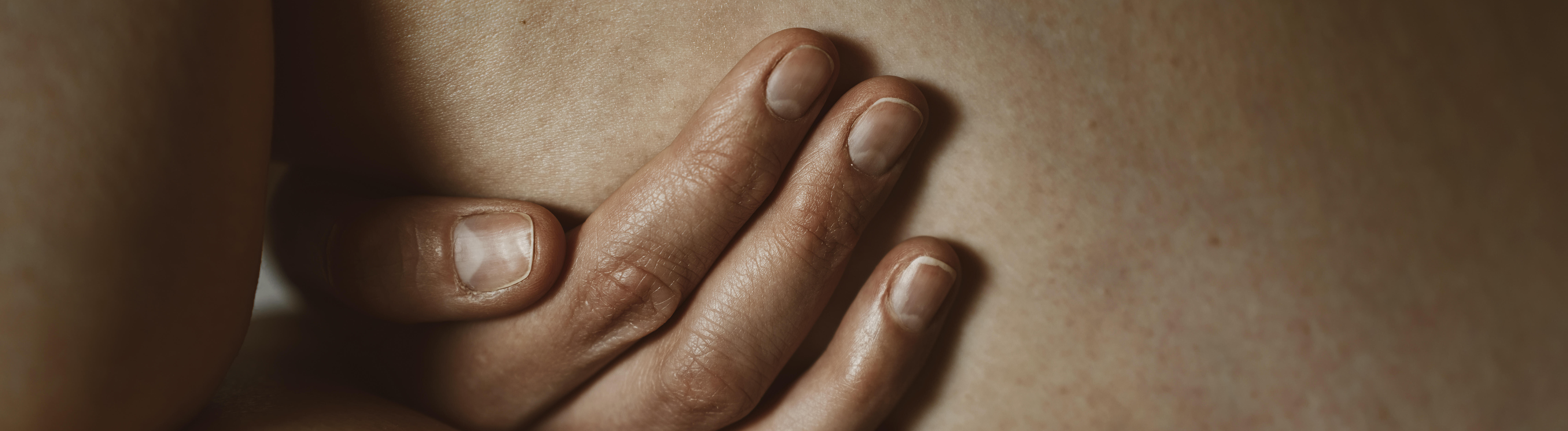 Nahaufnahme einer Hand, die sinnlich und intim ein Bein berührt