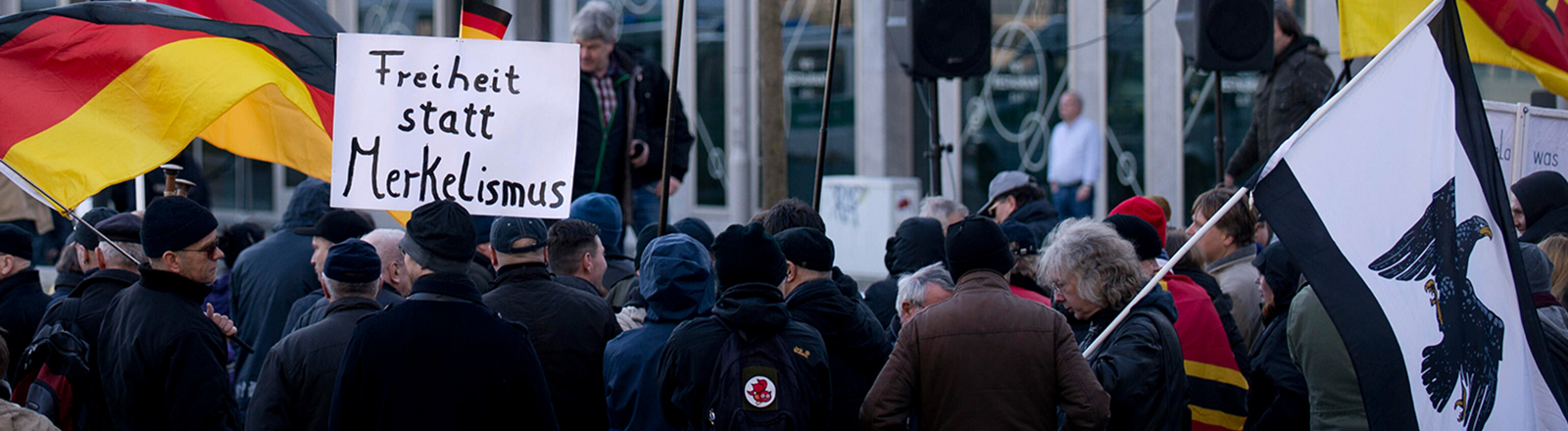 Demonstranten mit Plakat Freiheit statt Merkelismus und Fahnen in Schwarz-Rot-Gold auf einer Demonstration von Baergida bzw. Bergida, einer Form von Pegida, am 06.02.2016 am Hauptbahnhof im Regierungsviertel in Berlin