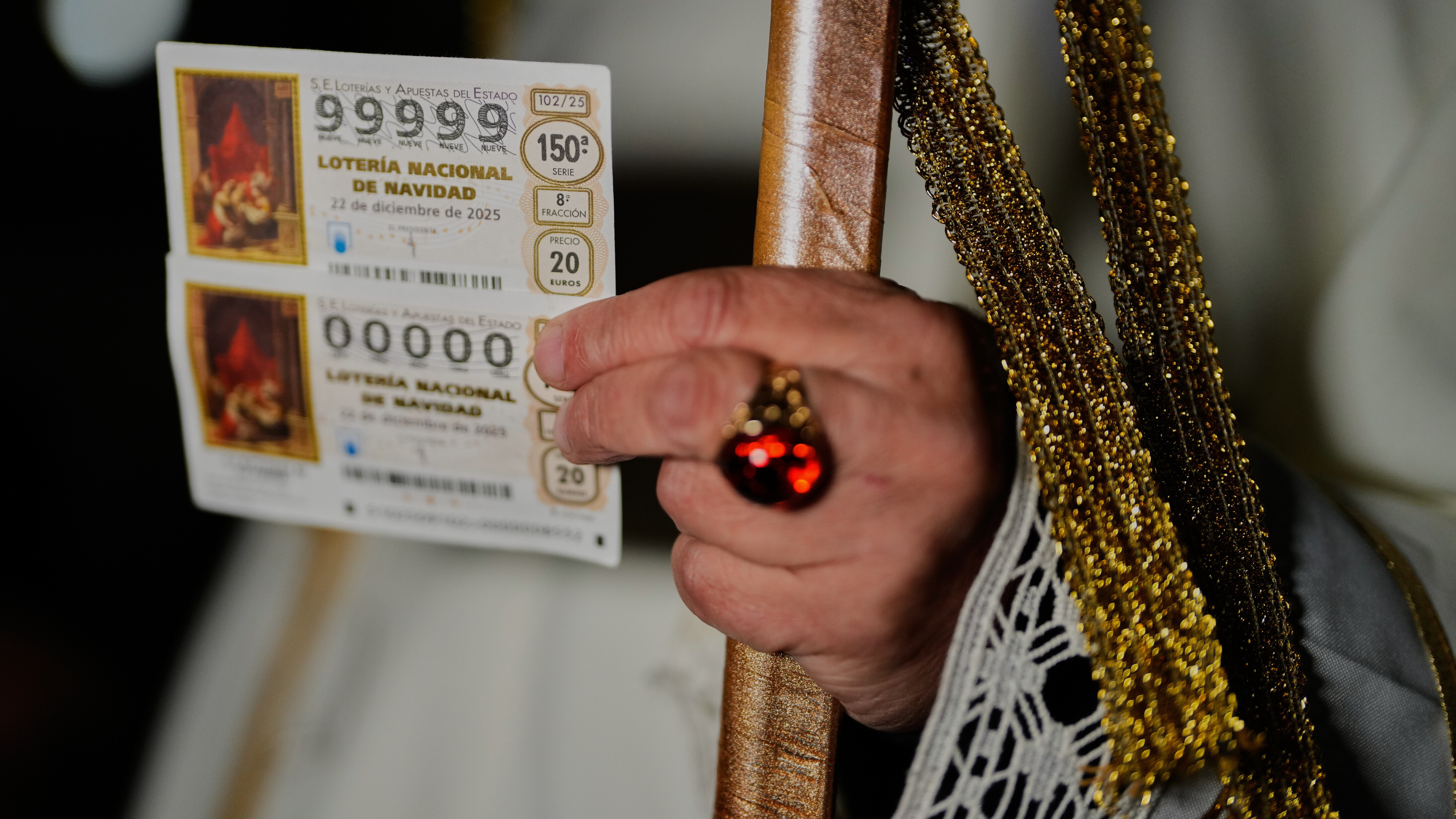 Eine Person hält einen Los-Schein für die spanische Weihnachtslotterie "El Gordo" in der Hand.