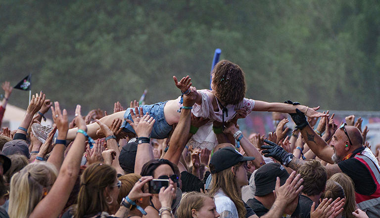 Foto einer Festivalbesucherin beim Hurricane Festival 2023 in Scheeßel, die vor der Bühne auf dem Rücken über die Menge surft.