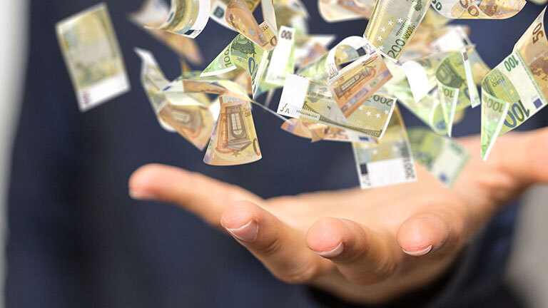 Geld fliegt in eine Hand