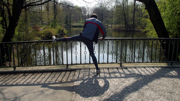 Ein Jogger bei Dehnungsübungen im Berliner Tiergarten