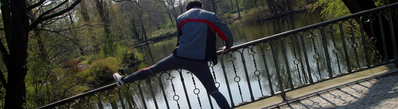 Ein Jogger bei Dehnungsübungen im Berliner Tiergarten