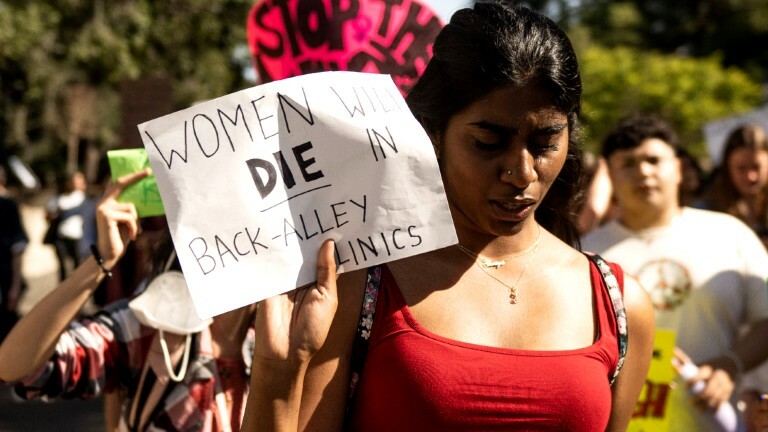 Eine Frau hält bei einer Demonstration ein Plakat, auf dem steht: "Women will die in Back Alley Clinics". Eine Demonstration in Berkeley gegen die Änderung des Abtreibungsgesetzes in den USA.