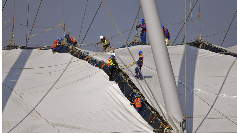 05.01.2017: Dutzende Arbeiter, an Seilen gesichert, befestigen die Dachkonstruktion des Khalifa International Stadions westlich von Doha, das für die Fussball-WM 2022 in Katar gebaut wurde