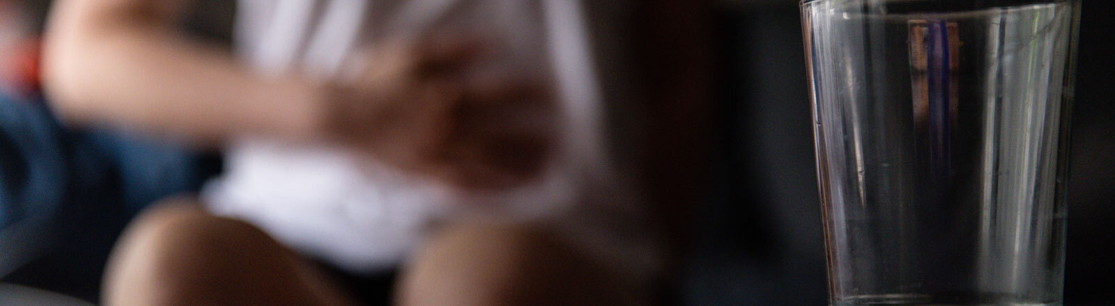 Eine Frau hat Bauchschmerzen und liegt auf einem Sofa.