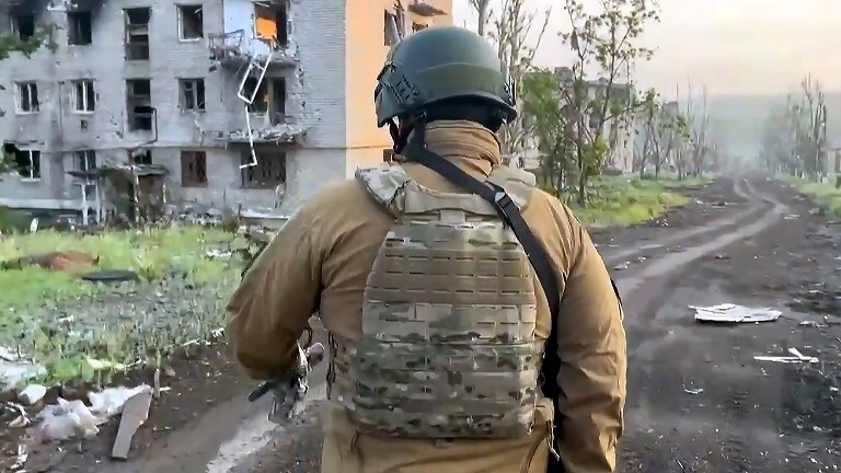 Wagner-Chef Prigoschin läuft an einem zerstörten Gebäude vorbei.