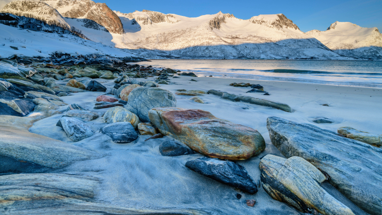 Gestein und Felsen an einem Strand in einem Fjord in Norwegen.