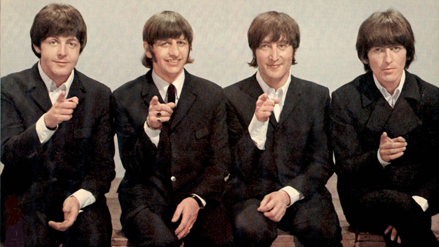 Die Beatles auf einem Foto aus dem Jahr 1966 - Paul McCartney, Ringo Starr, George Harrison und John Lennon zeigen mit dem Finger in die Kamera.