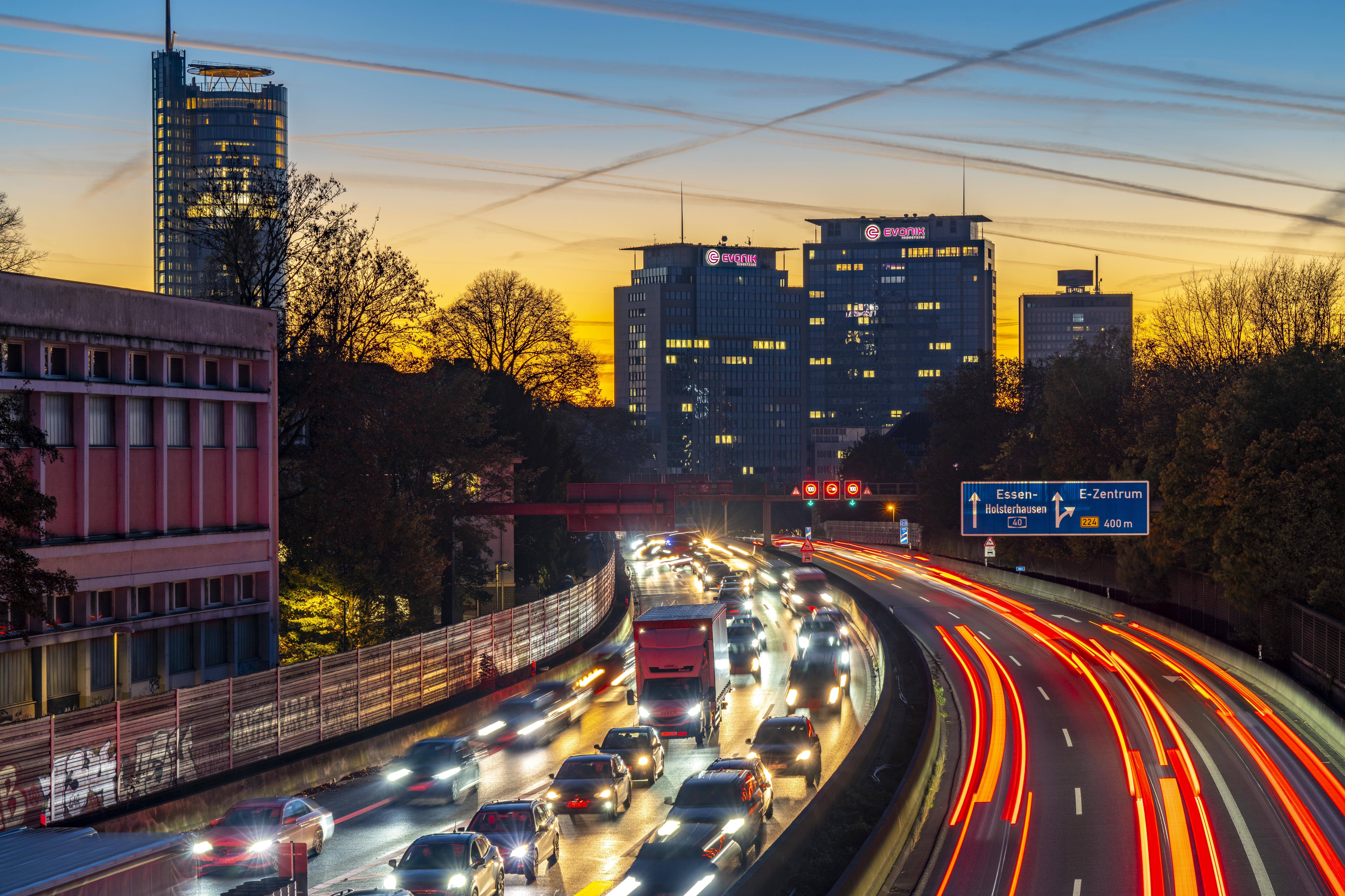 Abendlicher Verkehr, teils mit Stau, zäh fließendem Verkehr auf der Autobahn A40, Skyline von Essen, links RWE Turm, Mitte Evonik Konzern Zentrale, Essen, NRW, Deutschland Verkehr A40 Essen