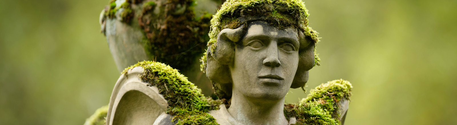 Verwunschene, moosbedeckte Sphinx-Statue mit Urne voller Magie, Geschichte und Mystik im Licht des Melaten-Friedhofs, Köln