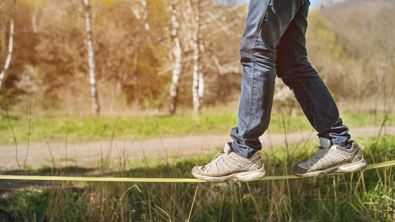 Ein Mann balanciert auf einer Slackline