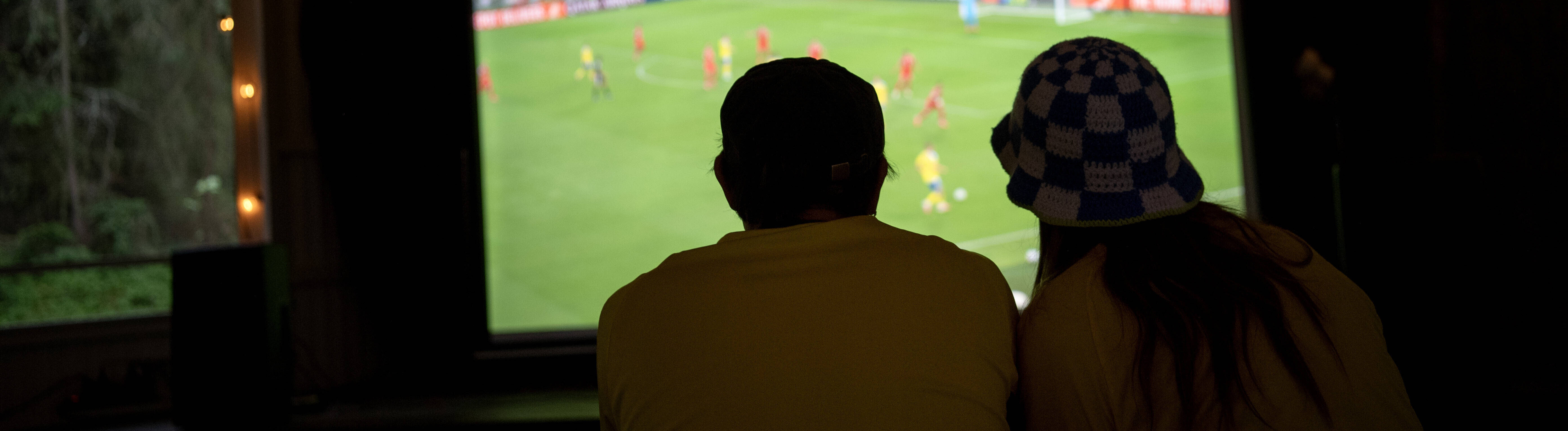 Fußballfans schauen ein Spiel der Fußball-Weltmeisterschaft auf einem großen Bildschirm