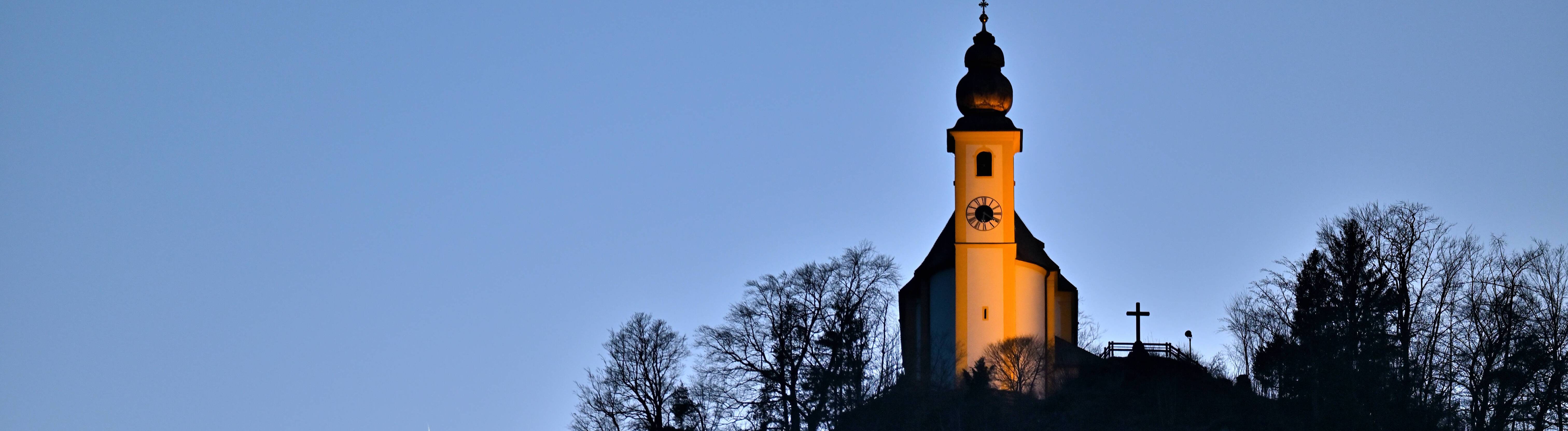 Die Wallfahrtskirche St.Pankraz steht auf dem Karlstein, einem Felsen, bei Bad Reichenhall und wird von der Abendsonnen angestrahlt.
