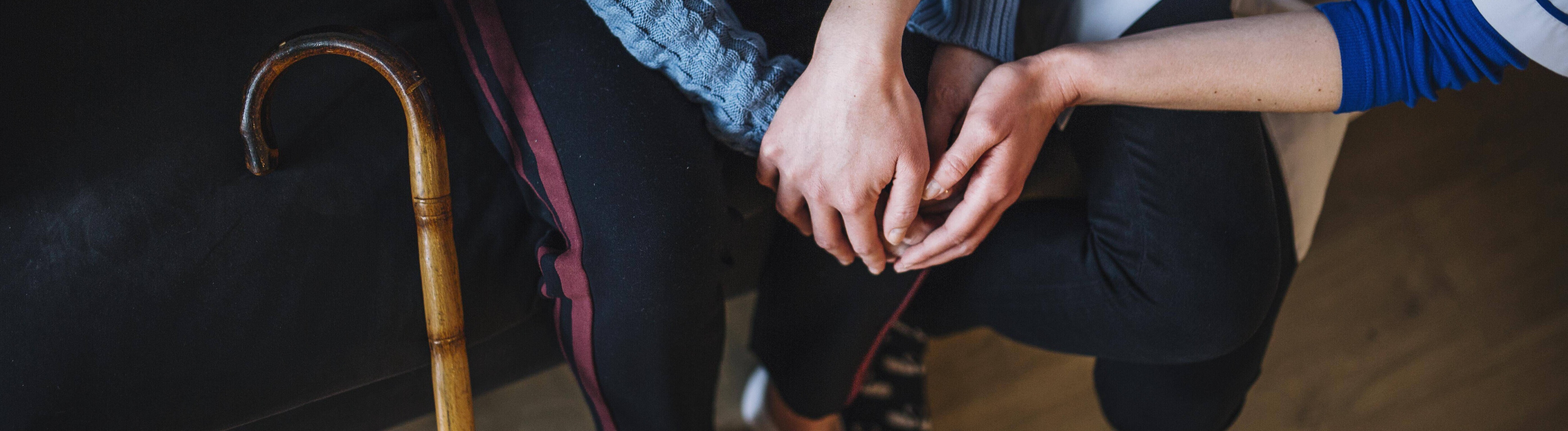 Symbolbild Pflege Eine Krankenschwester hält die Hände einer älteren Frau.