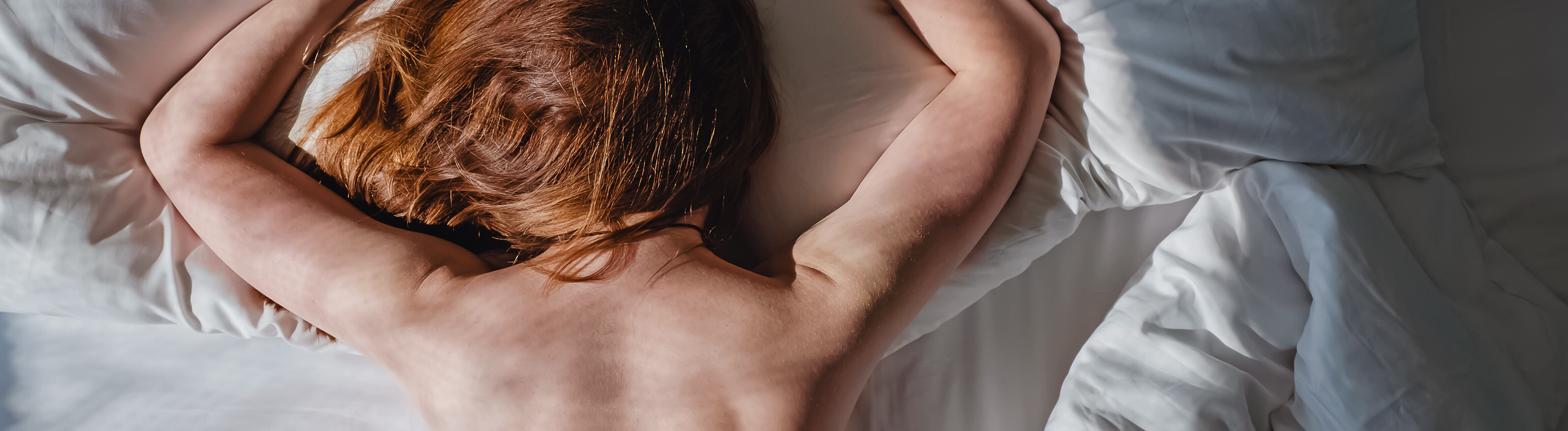 Eine Frau liegt bäuchlings in einem Bett