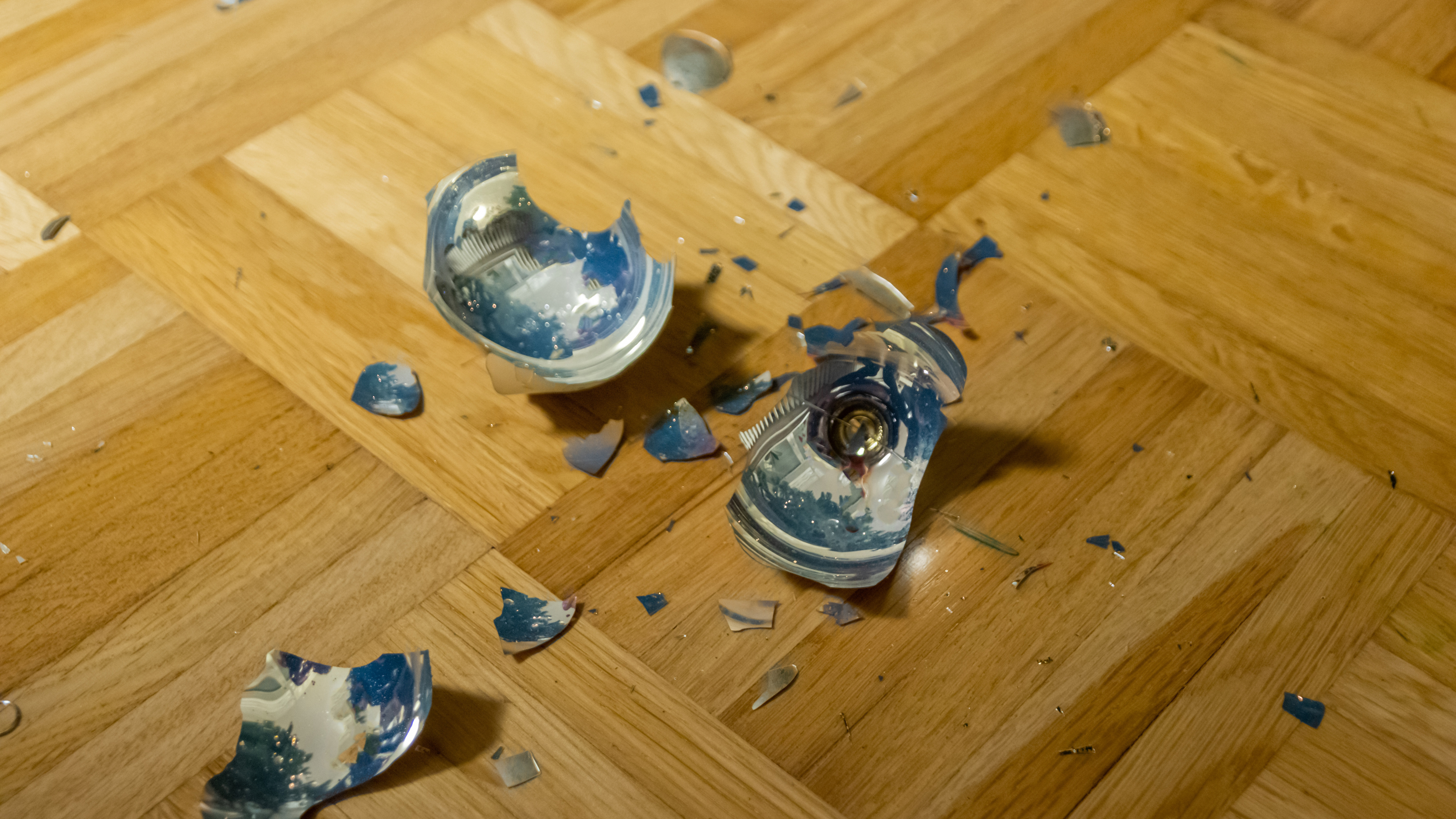 Auf dem Parkettboden liegt eine zerbrochene Christbaumkugel.