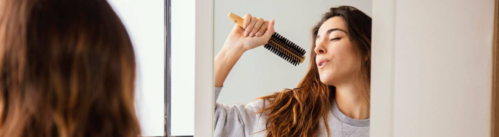 Eine Frau singt in eine Haarbürste
