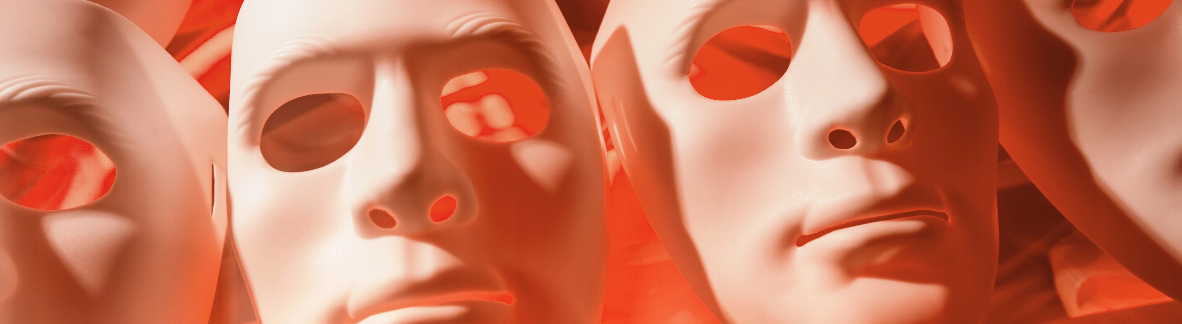 Weiße Masken, von hinten rot angeleuchtet