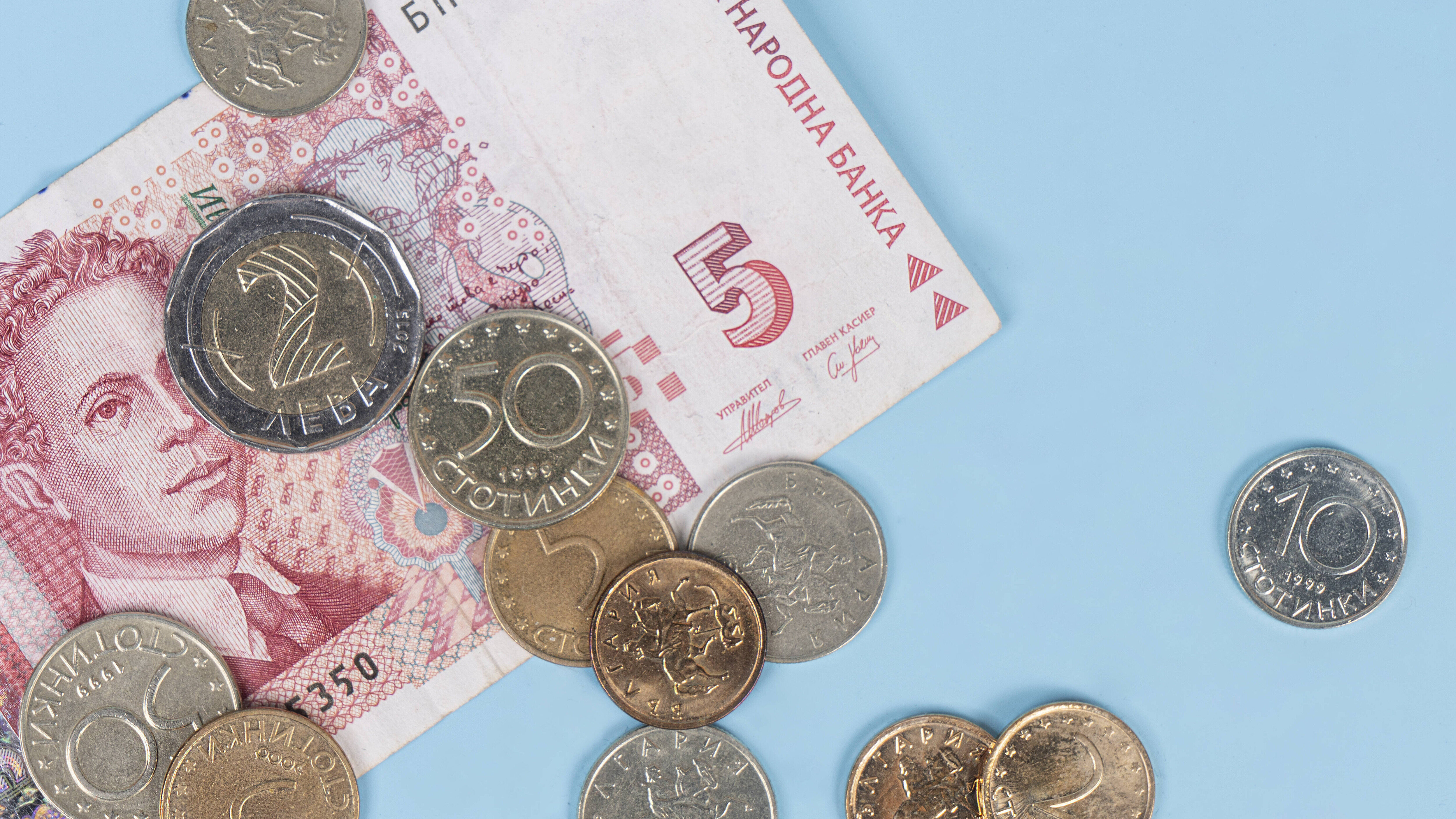Ein 5-Lewa-Schein sowie Münzen auf hellblauem Hintergrund
