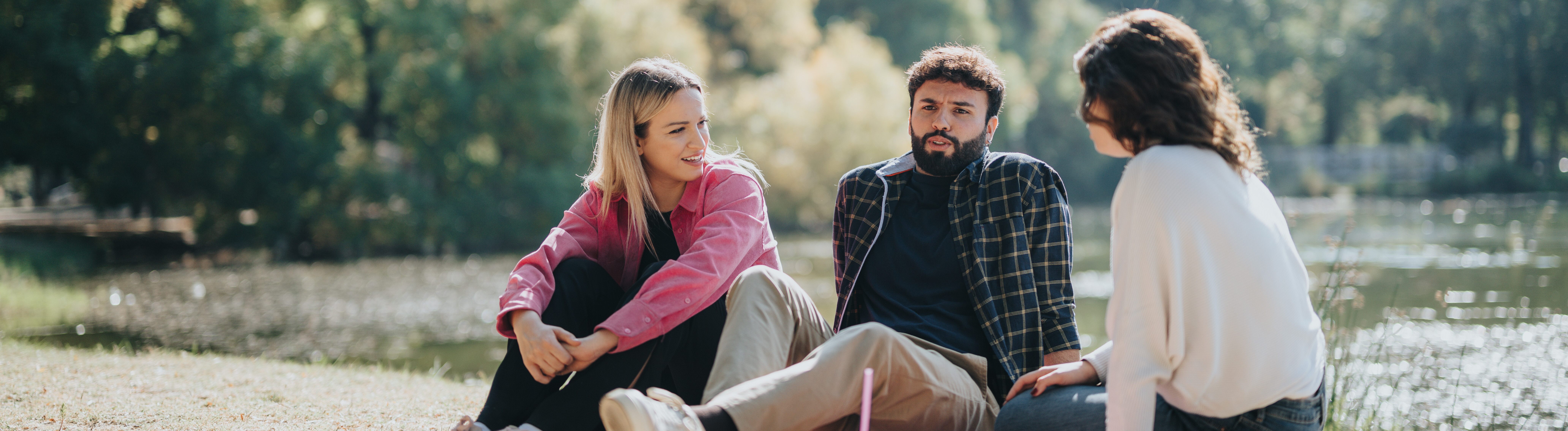 Drei Freunde sitzen in einem Park und unterhalten sich