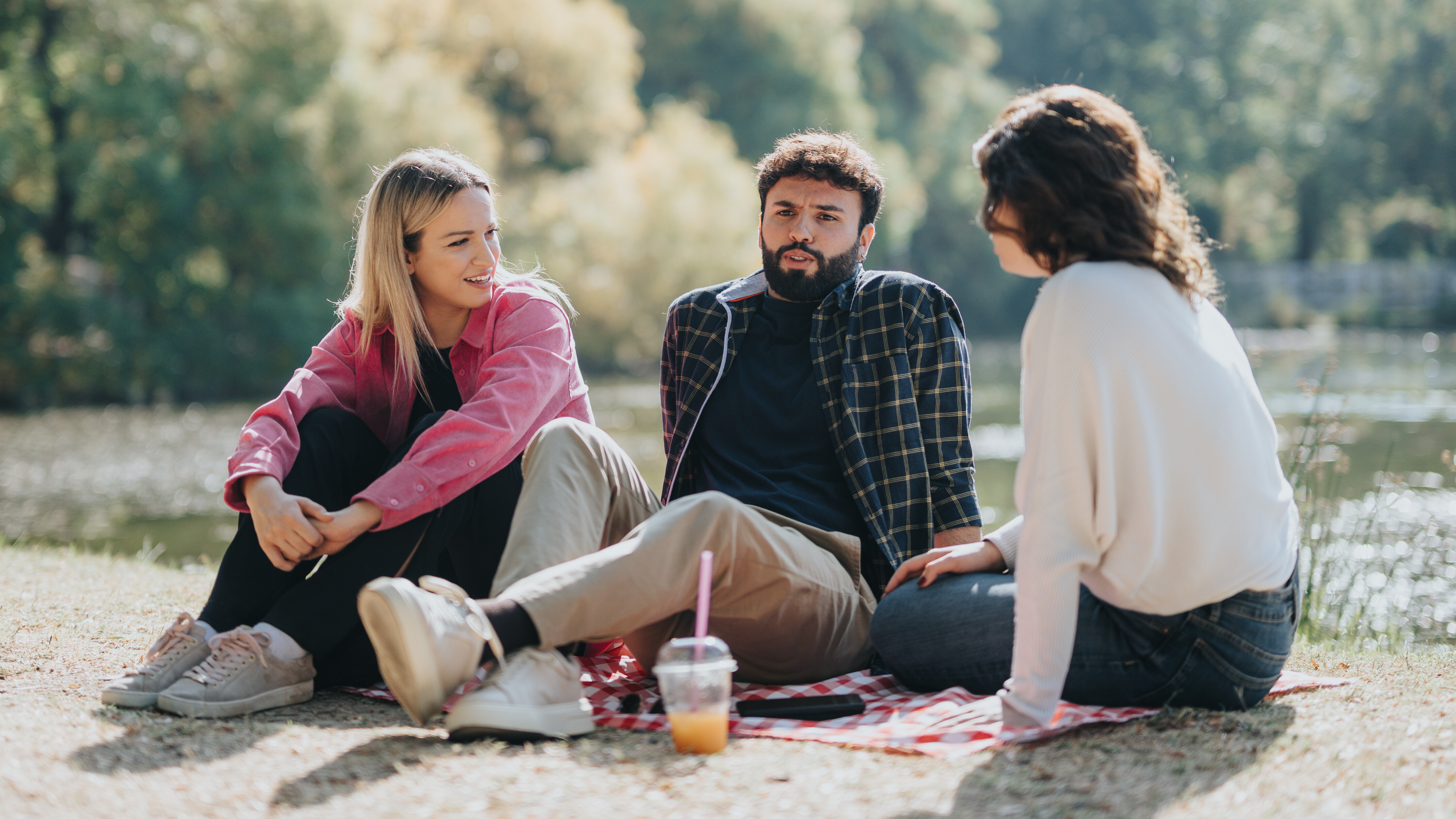 Drei Freunde sitzen in einem Park und unterhalten sich