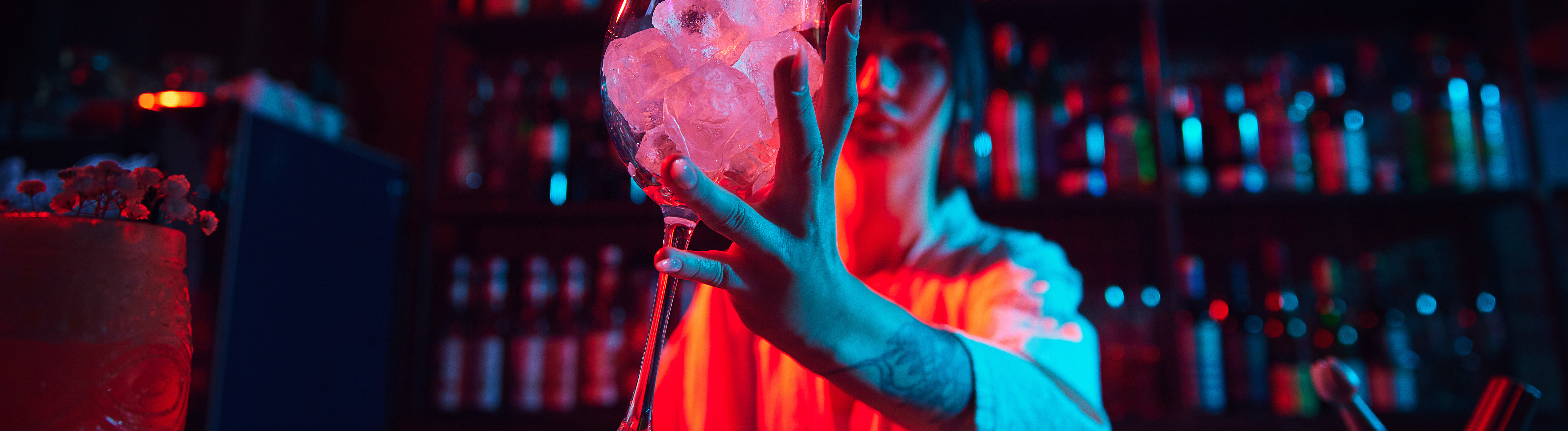 Eine Barkeeperin reicht ein Glas über die Theke.