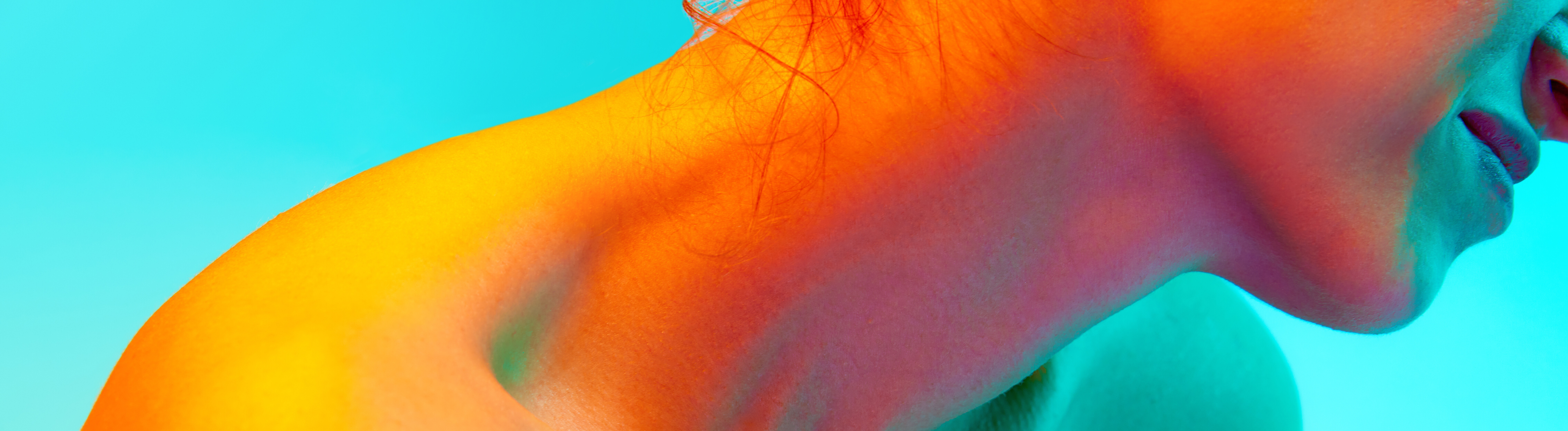 Nackter weiblicher Körper, Frau sitzt und bedeckt Brust mit der Hand vor blauem Hintergrund in Neonlicht.