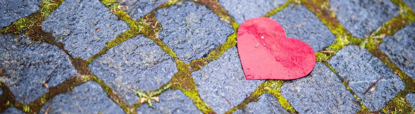 Ein Herz aus Papier liegt auf dem Boden