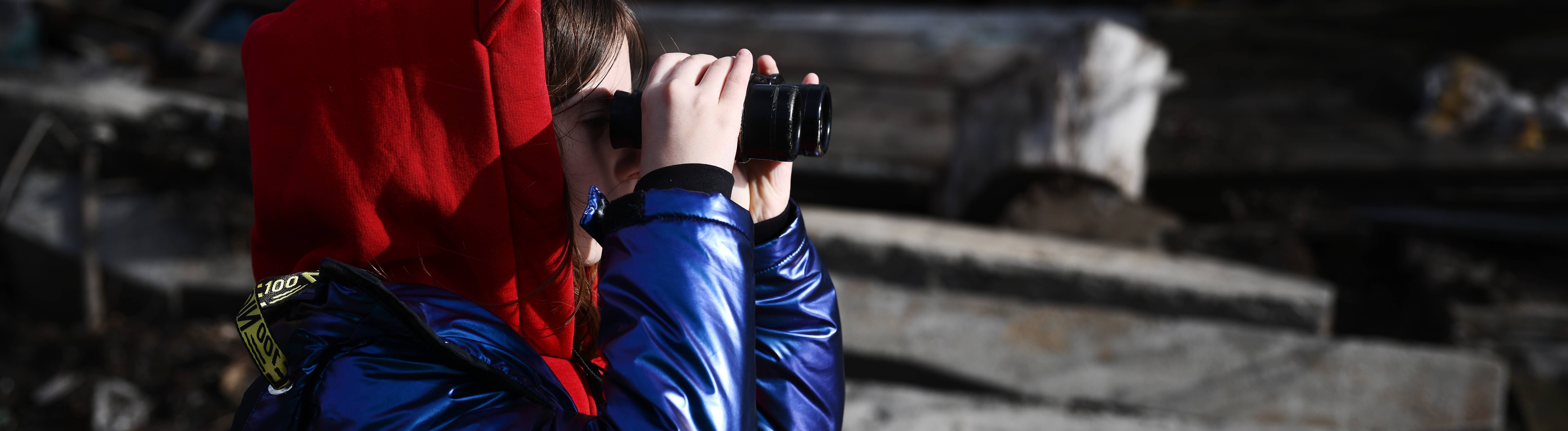 Ein Mädchen schaut durch ein Fernglas