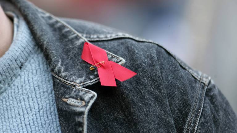 Rote Aidsschleife auf schwarzer Jeansjacke