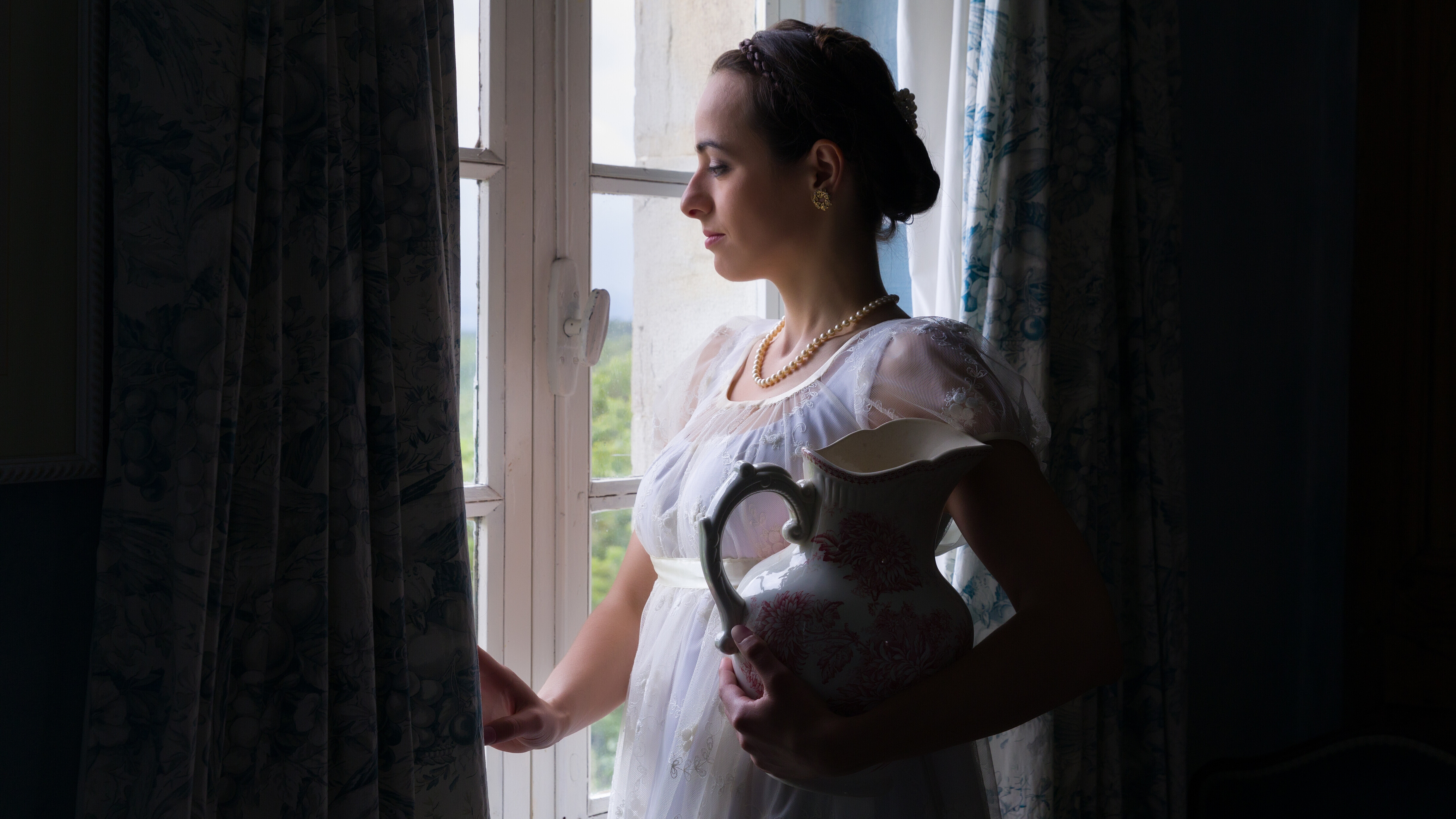 Eine Frau, die im Stil des frühen 19. Jahrhunderts angezogen und gestylt ist.