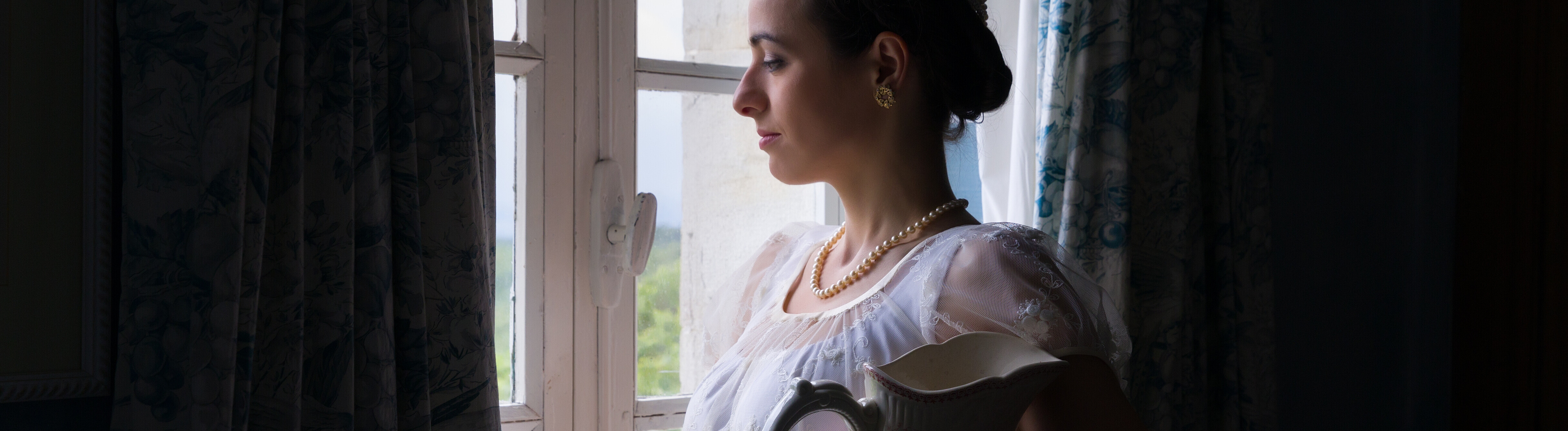 Eine Frau, die im Stil des frühen 19. Jahrhunderts angezogen und gestylt ist.