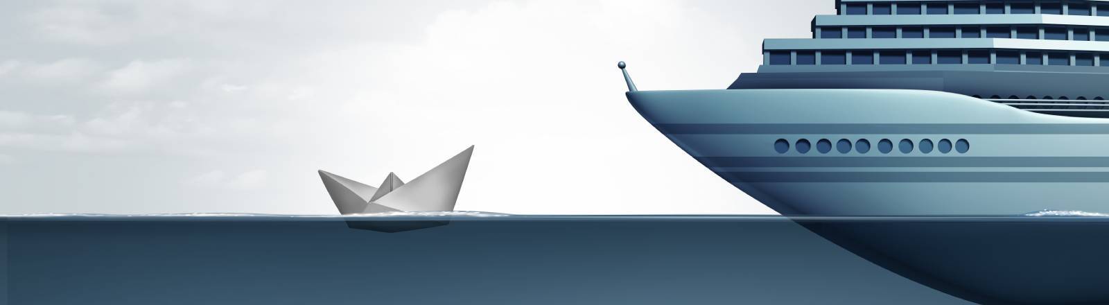 Eine riesige Luxusyacht steht einem kleinen Papierboot auf See gegenüber. Symbolbild für wirtschaftliche Ungleichheit