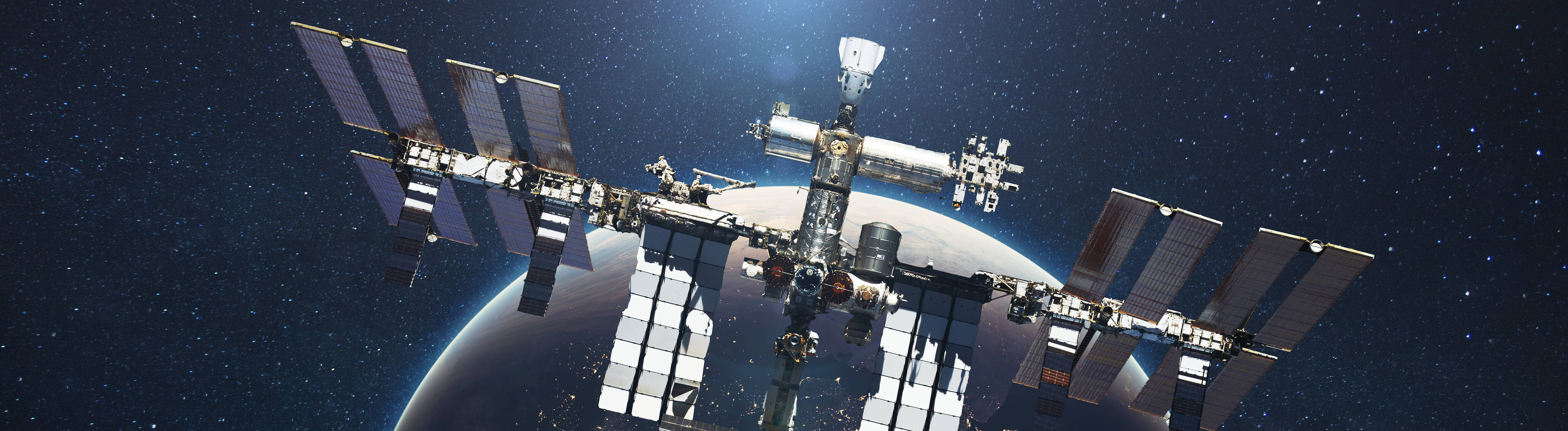 Die ISS fliegt vor dem Hintergrund des blauen Planeten Erde mit dem Licht der Sonne.