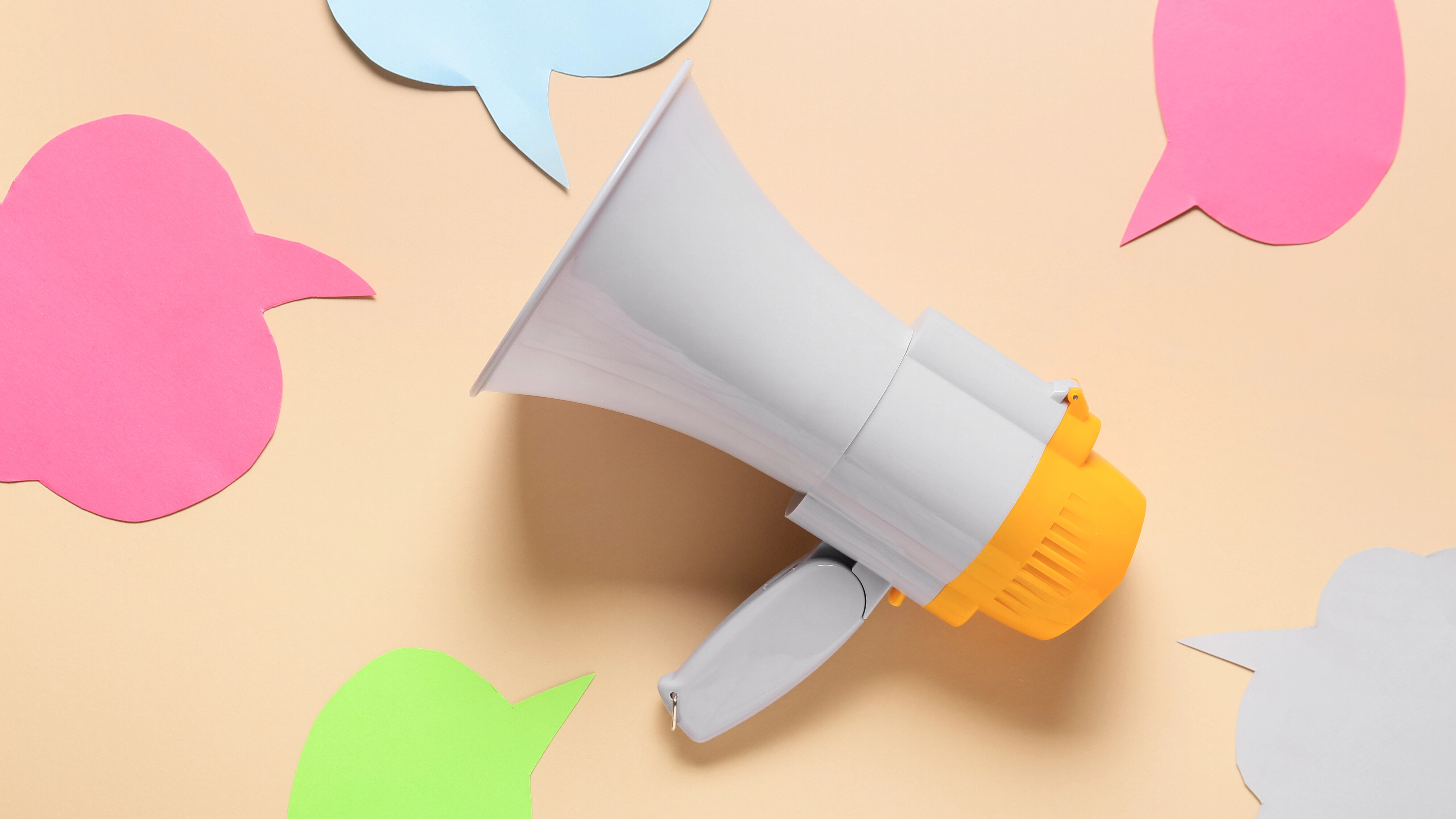 Megaphon und Sprechblasen auf farbigem Hintergrund