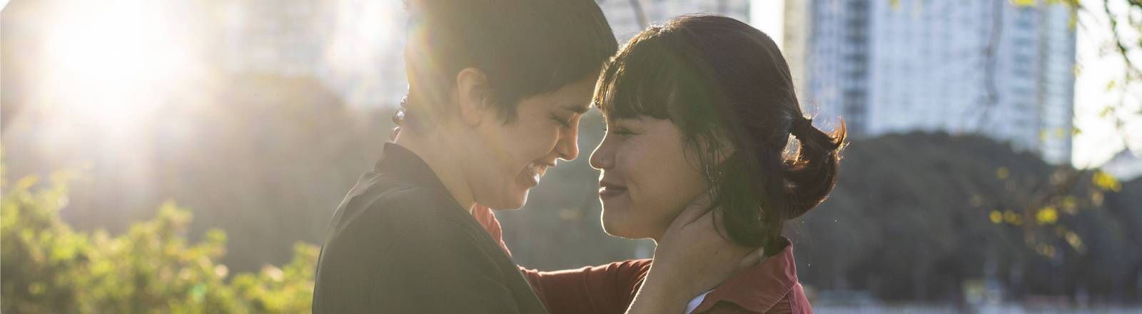 Zwei Frauen, die sich bei Sonnenaufgang gegenseitig festhalten und in die Augen schauen