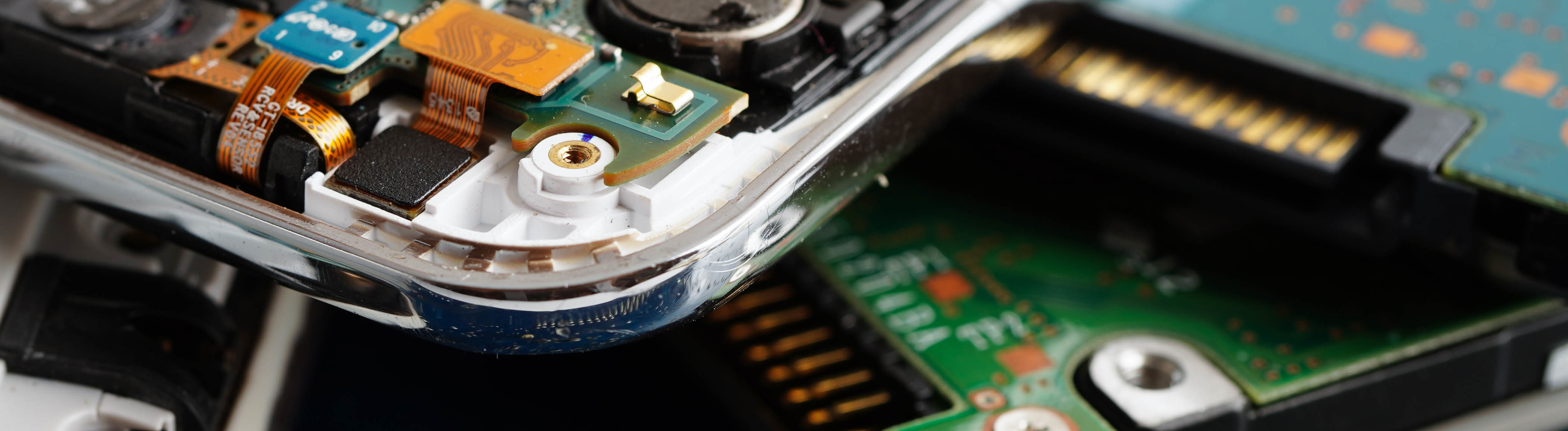 Mehrere aufgeschraubte Smartphones, von denen man Platinen und das Innere sieht.