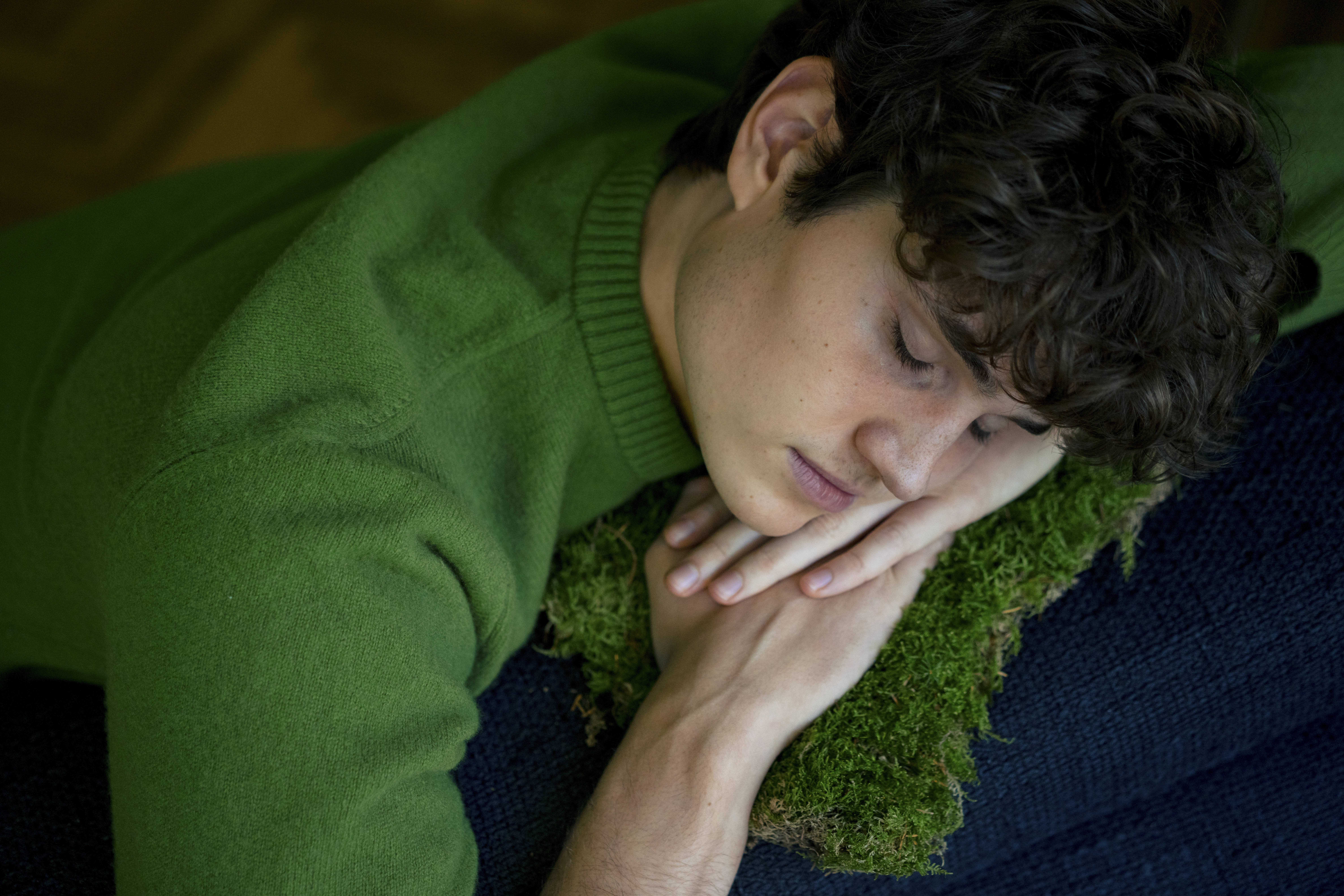 Ein junger Mann liegt auf dem Sofa und macht einen Mittagsschlaf