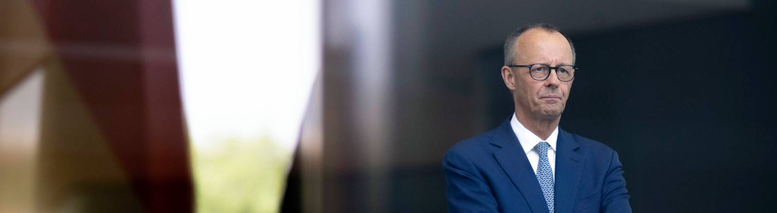 Bundeskanzler Friedrich Merz (CDU) mit ernstem Blick in die Ferne und verschränkten Armen im Foyer des Bundeskanzleramtes in Berlin (11.06.2025)