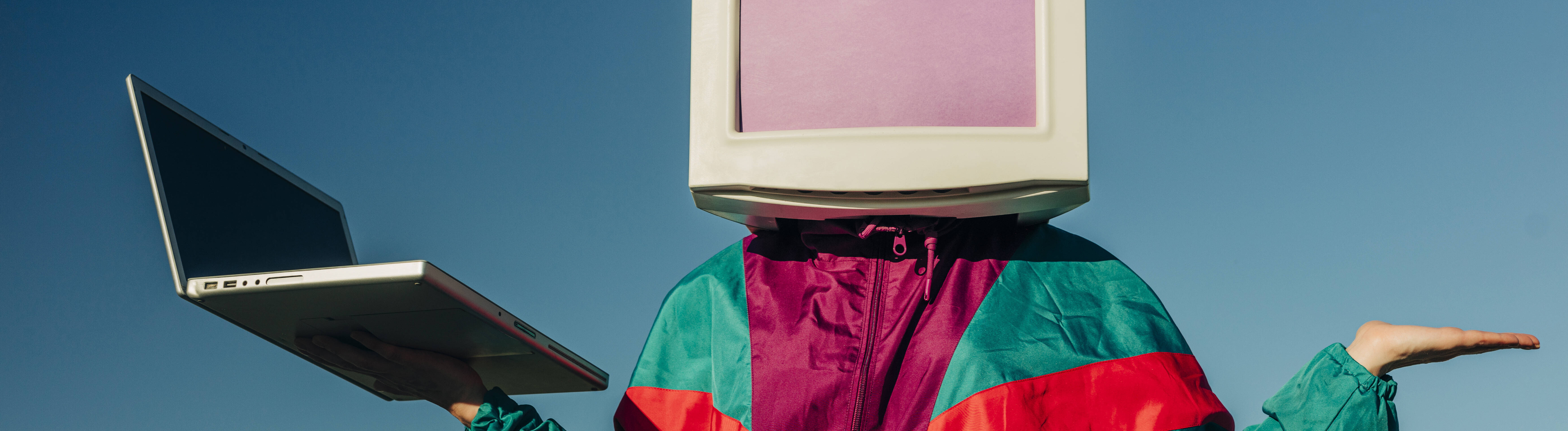 AI-Konzeptfigur in Vintage-Trainingsanzug mit CRT-Monitor-Kopf und Laptop.