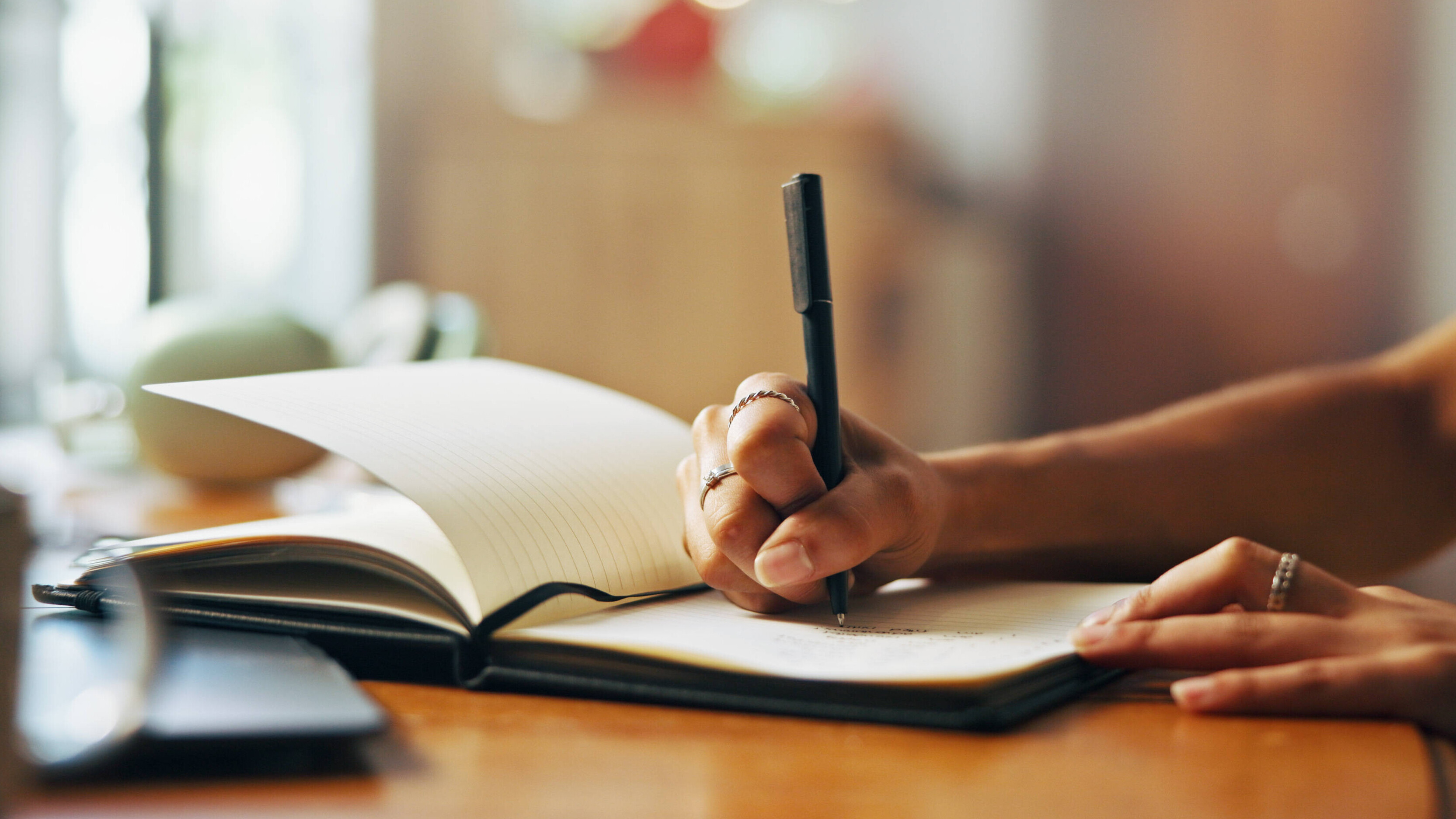 Jemand schreibt eine Liste in ein Notizbuch