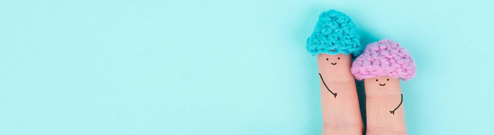 Zwei Finger nebeneinander, auf die lächelnde Gesicht gemalt sind