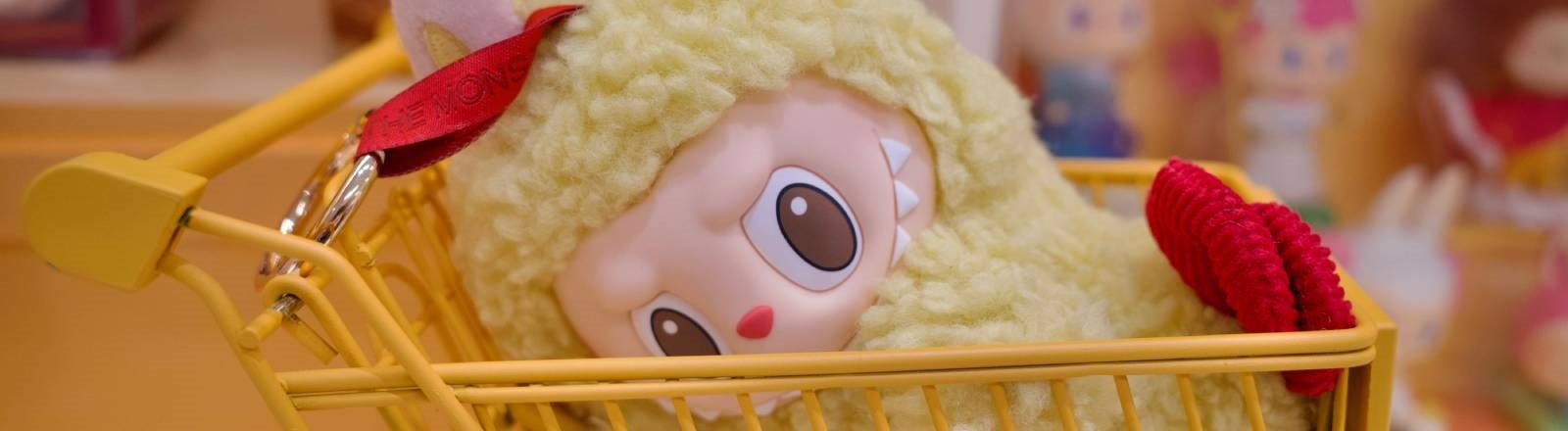 Eine Labubu-Plüschfigur liegt in einem Einkaufswagen
