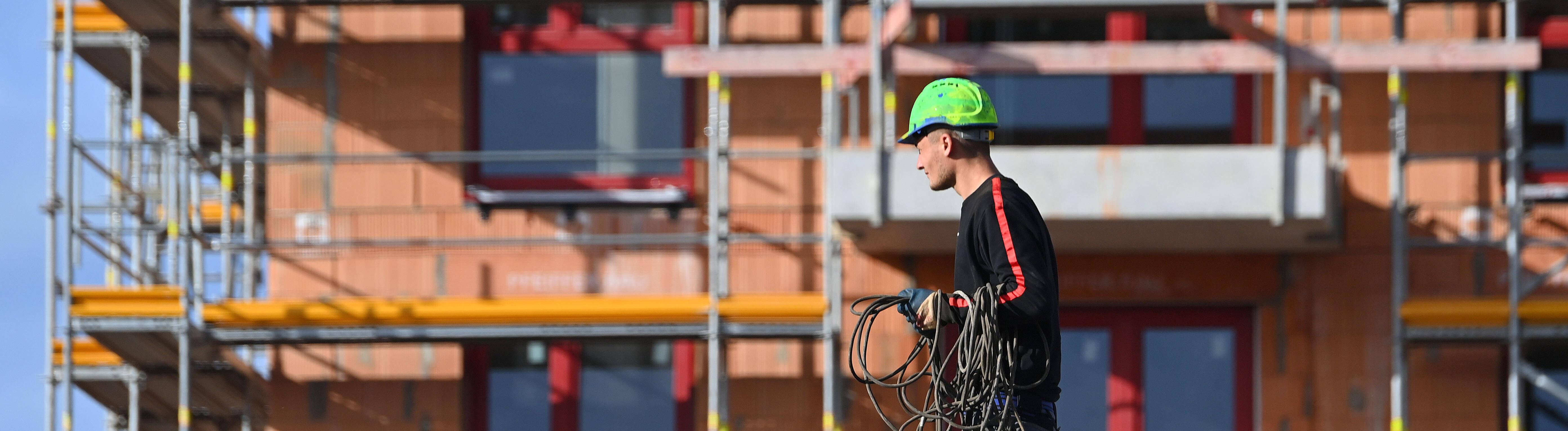 Bauarbeiter auf einer Großbaustelle eines Mehrfamilienhauses