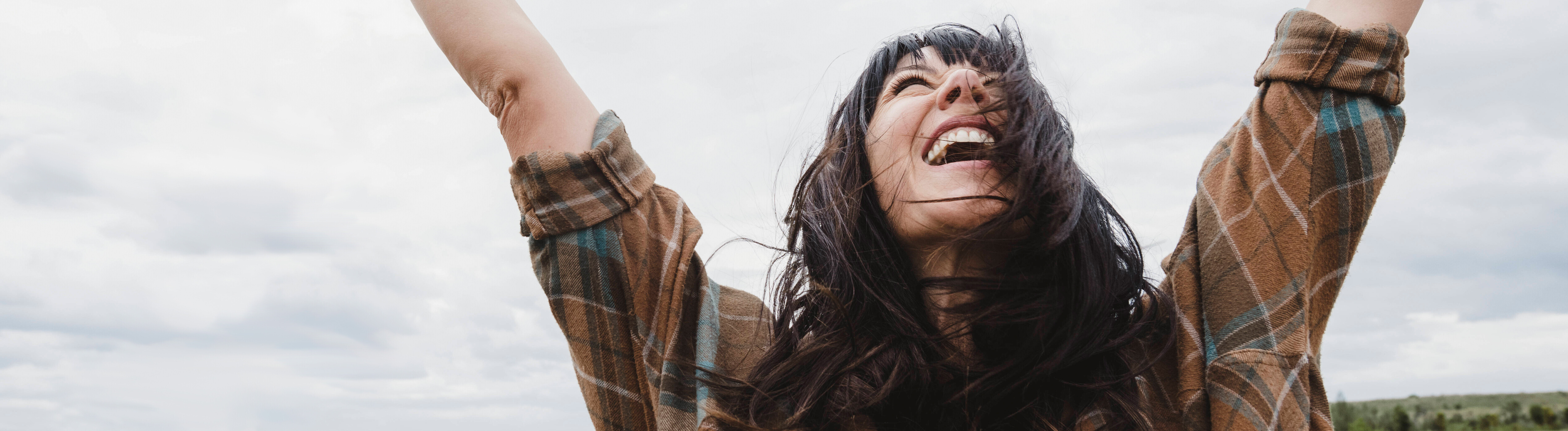 Eine Frau freut sich überschwänglich und reißt dabei die Arme in die Luft