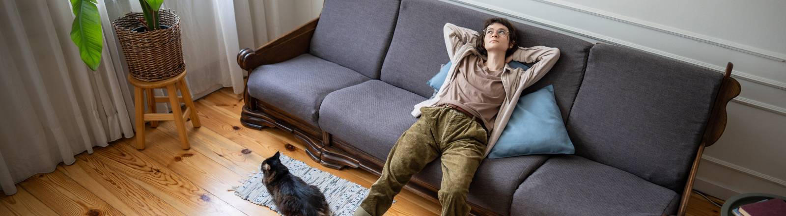 Eine Frau liegt gelangweilt auf dem Sofa