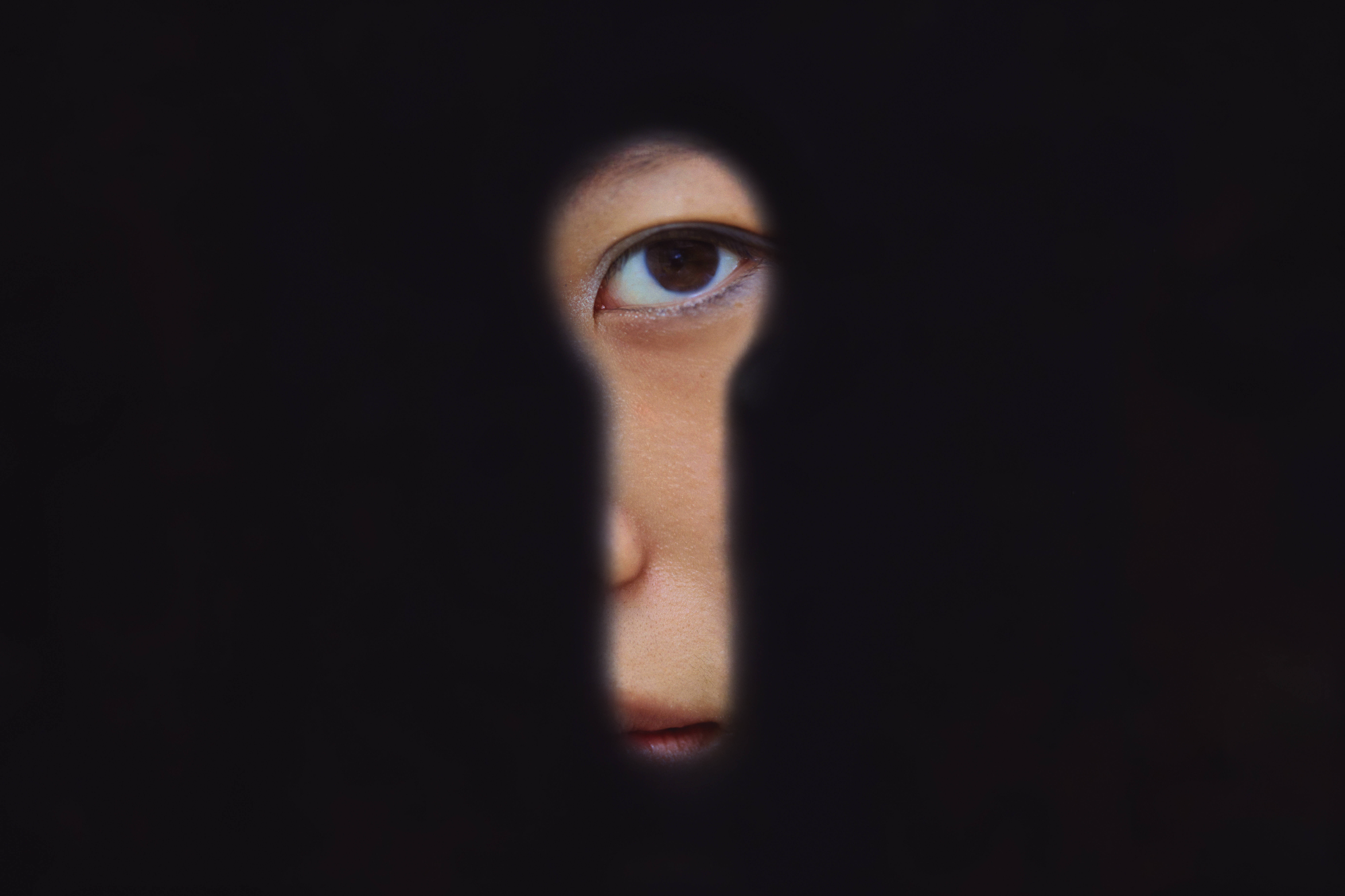 Eine chinesische Frau blickt in Schanghai durch ein Schlüsselloch