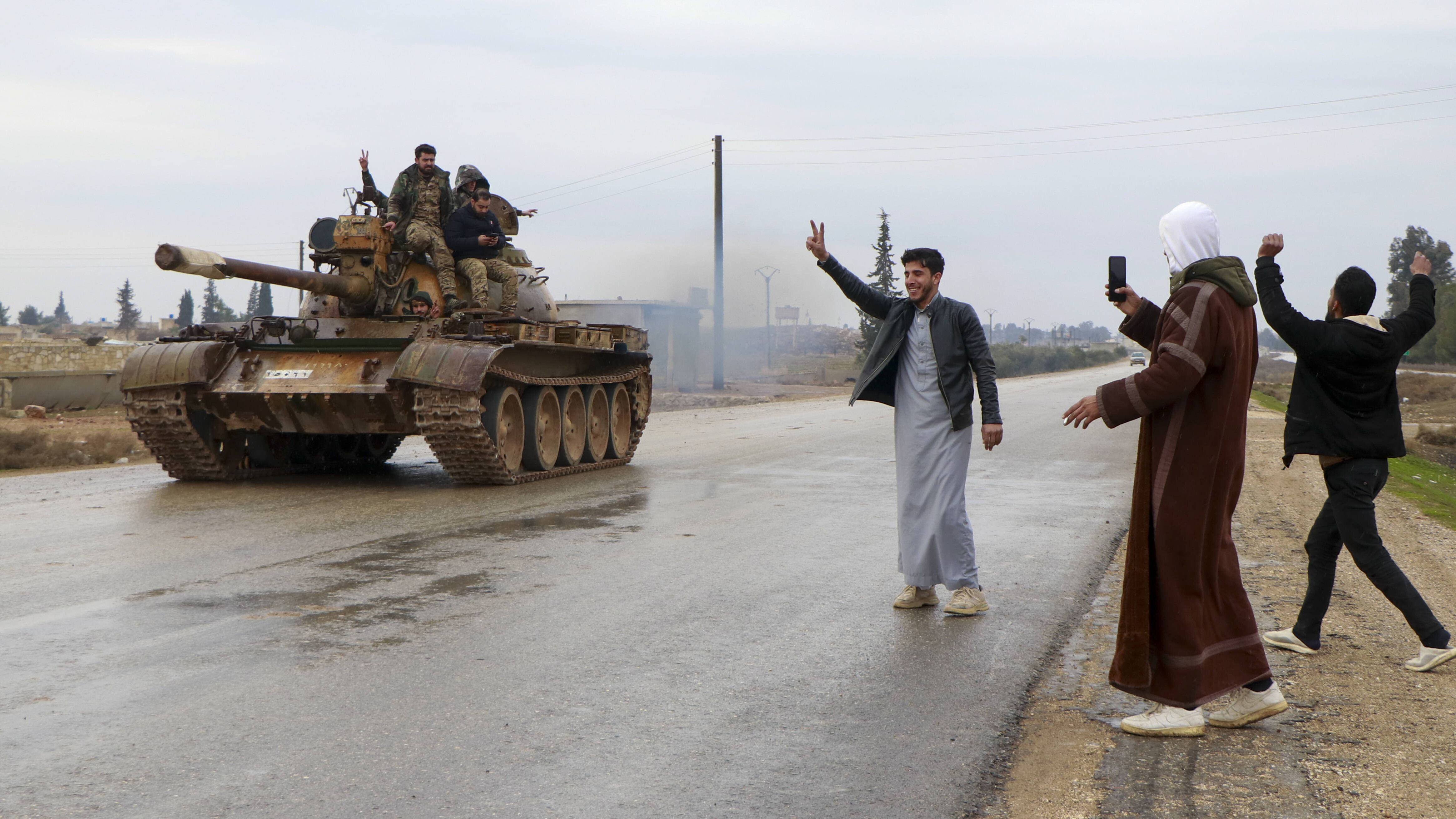 Menschen jubeln bei Rakka einem Panzer der Armee zu