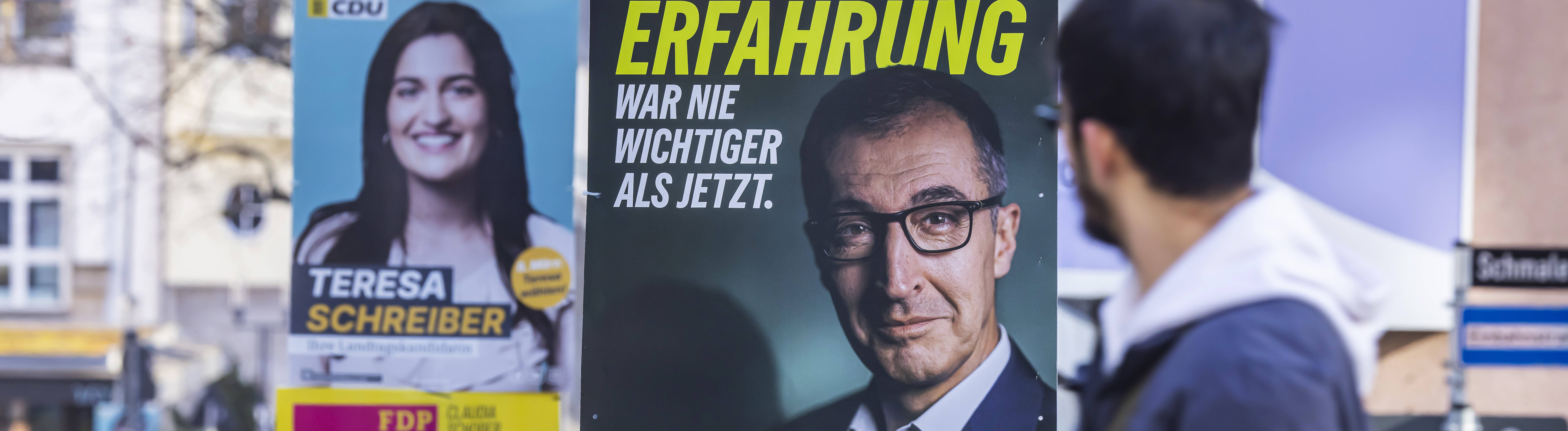 Mann schaut auf ein Wahlplakat mit Özdemir